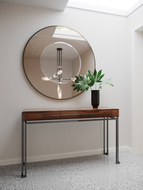 Image Description: Round decorative mirror with two tones and a wood and stainless steel console.