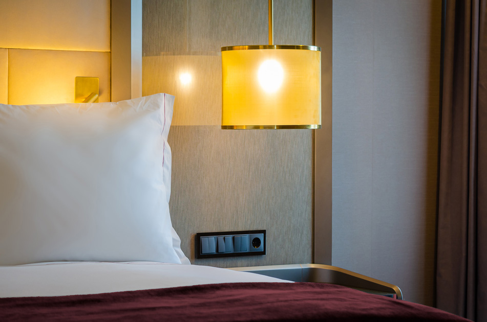 Description de l’image: détail de l’éclairage au-dessus de la table de nuit dans chambre à coucher comme à l’hôtel.