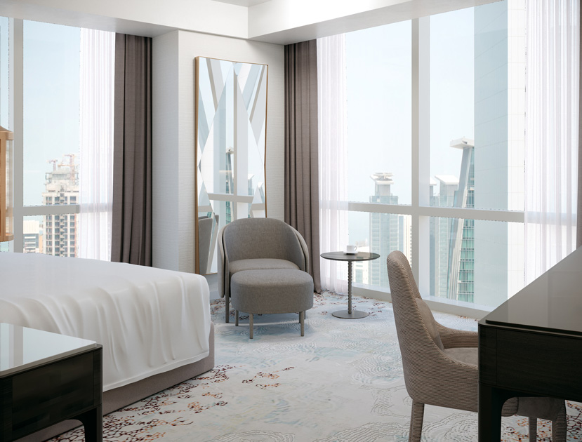 Image description: reading corner with armchair, foot stool and side table in a hotel bedroom